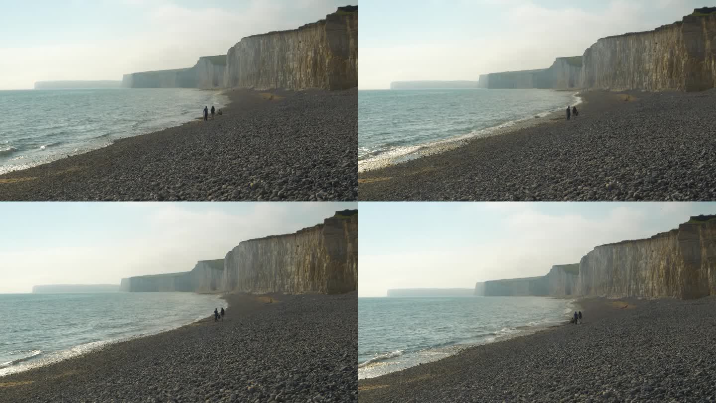 在雄伟的白垩海崖下，小海浪翻滚在岩石海滩上