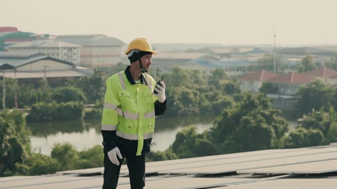 高效运行:亚洲工程师检查屋顶上的光伏太阳能电池板是否可持续发电。