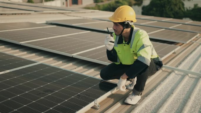 高效运行:亚洲工程师检查屋顶上的光伏太阳能电池板是否可持续发电。