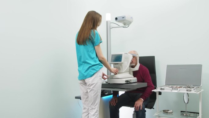 一位老人在一家现代化的诊所里接受眼科检查。专家使用眼科诊断设备检查视力。
