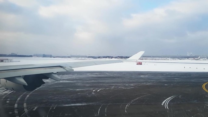 飞机在下雪的机场坡道上滑行