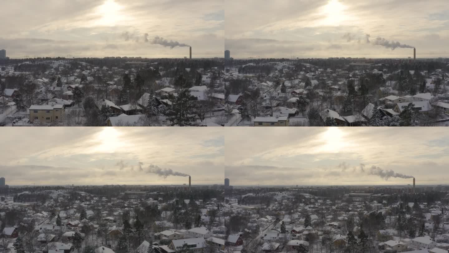 上升的无人机镜头揭示了区域供热厂的烟雾与冬季日落的发光色调的相互作用，形成了一个视觉上令人回味的场景