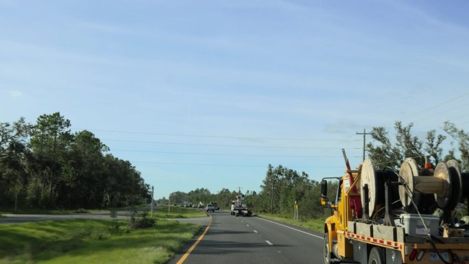 道路超车专用设备车队。北佛罗里达风暴过后，载着卷轴的卡车和维修人员协助救援。驱动板