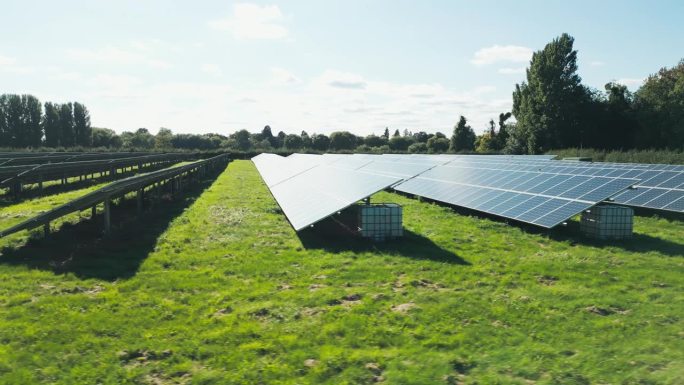 无人机拍摄跟踪过去的太阳能电池板在现场产生可再生的可持续能源