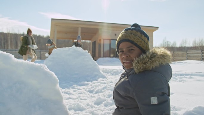 非裔美国男孩在晴天玩雪的肖像