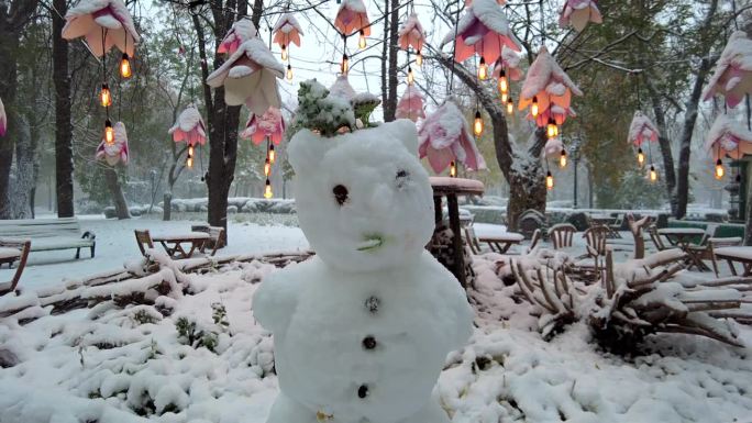 近距离拍摄公园里的雪人，冬天下着大雪