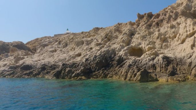 夏天，从法国鲁斯岛的一艘观光船上看到的山脉、岩石、海水和帆船。