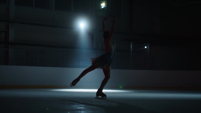 迷人的年轻女运动员独自在溜冰场滑冰，慢动作，专业运动和冰上表演