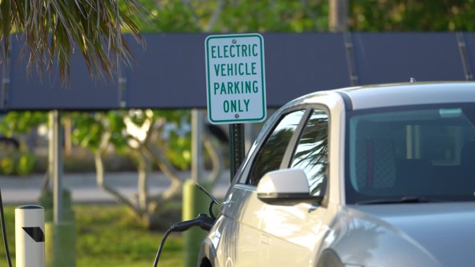 用太阳能可再生能源充电的插电式汽车停在城市街道上