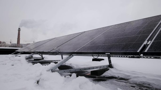 安装在建筑屋顶的光伏太阳能电池板，产生清洁的生态电力。生产可再生能源的理念。冬季