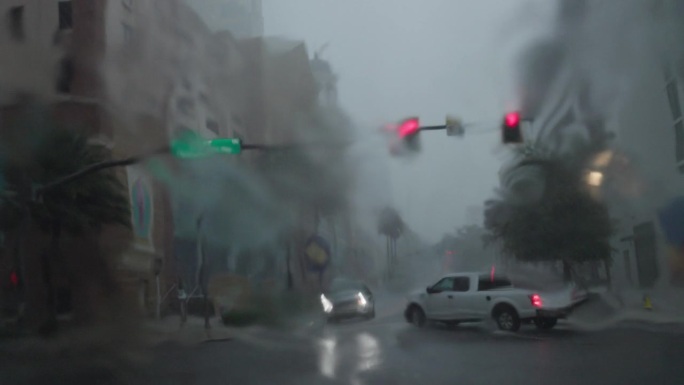 站在风暴中的红色。佛罗里达州圣彼得堡遭遇狂风暴雨，道路被洪水淹没。道路POV