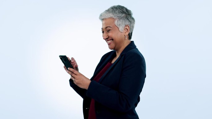 快乐，笑和高级商务女性与电话在工作室搞笑，短信或聊天在蓝色背景。智能手机、应用程序和上了年纪的女ce