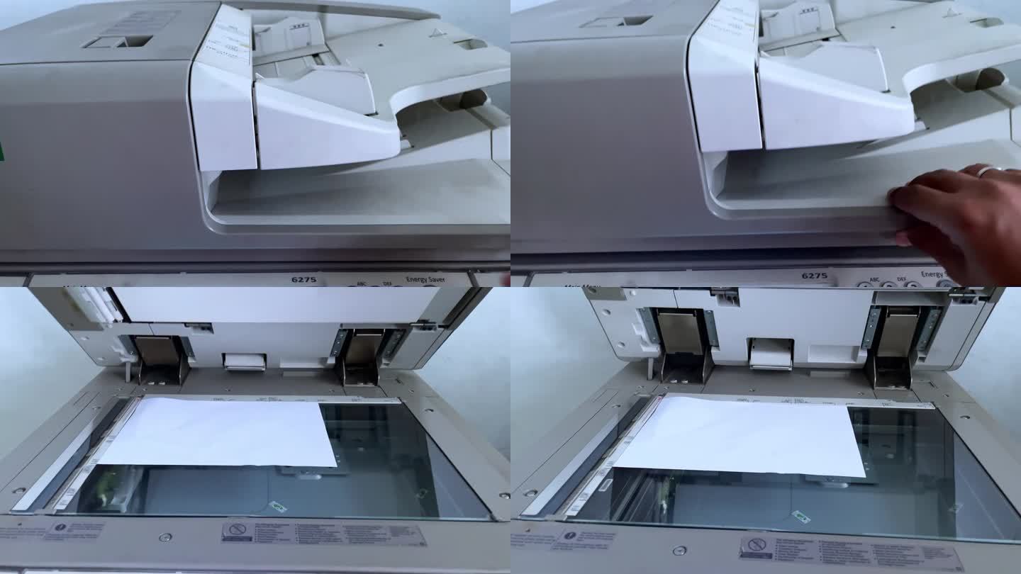 人手从复印机里拿纸。操作复印机