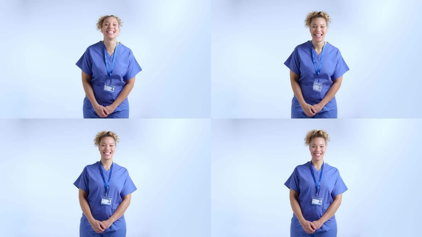 工作室肖像微笑的女护士穿着工作服对灰色背景