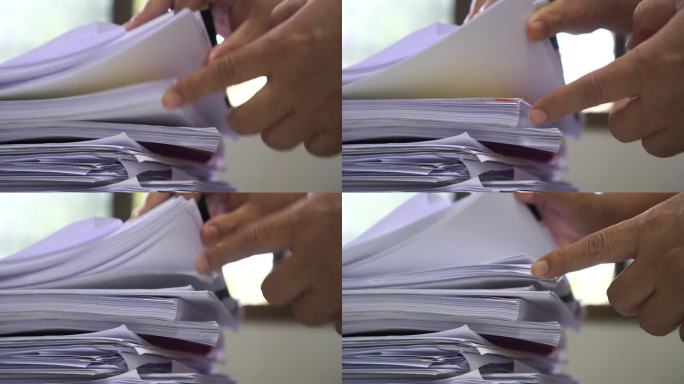 办公室工作人员整理成堆的查找信息的批件文件，办公桌上未完成的审计表格文件，成堆的调查工作量表