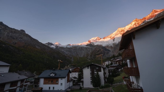 瑞士萨斯费村冰川格莱彻瑞士村晴朗的日出早晨电影延时起重机移动建筑工地区山峰照亮了第一缕光令人惊叹
