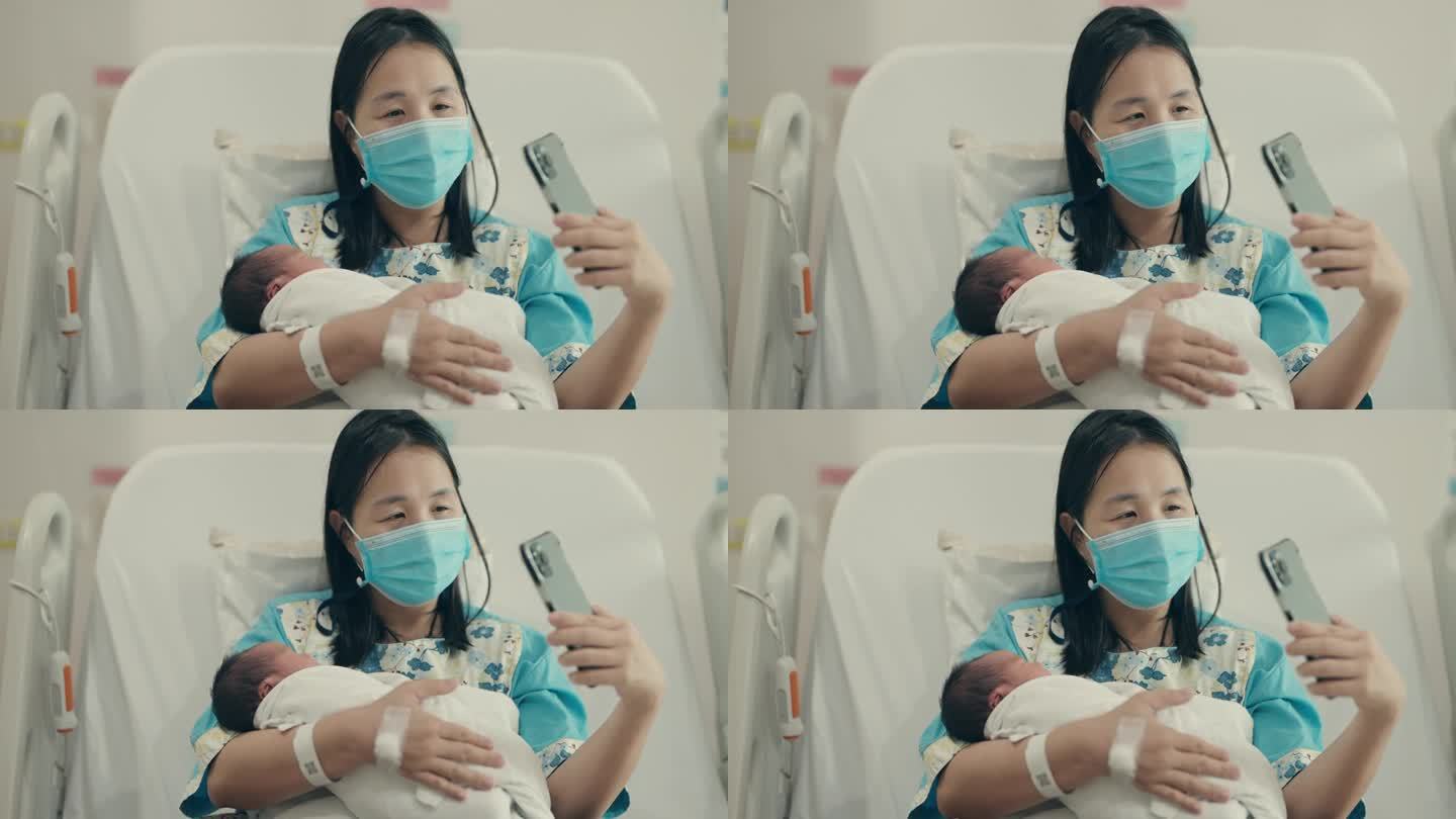 虚拟连接:亚洲孕妇拥抱母性，对着新生儿微笑，同时用智能手机和奶奶聊天。