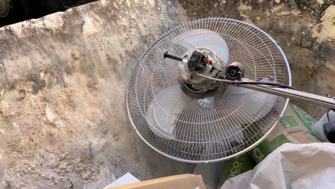 电风扇被扔进工业垃圾桶