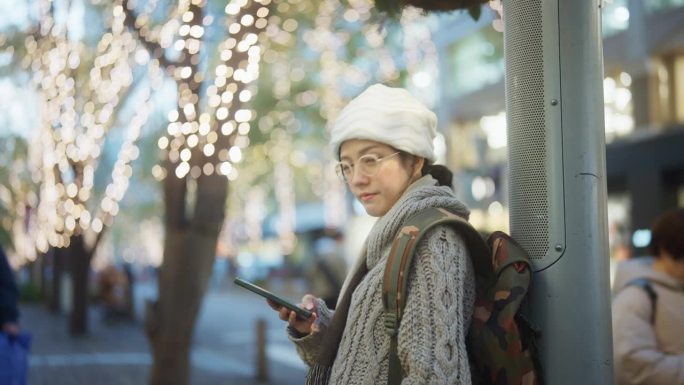 聪明的女人在日本市中心使用手机