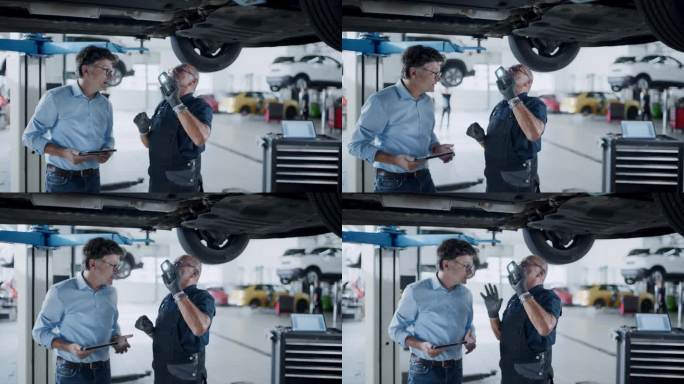 男机械师和经理在汽车修理店的车下谈话