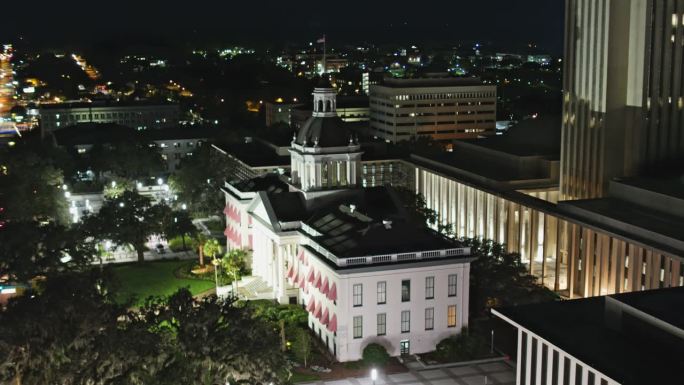 佛罗里达州塔拉哈西市中心的夜景。州议会大厦坐落在商业区的中心。航拍镜头与下降倾斜摄影机运动。