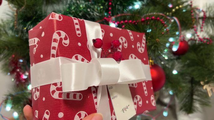 礼物放在圣诞树下。红盒子，黄胶带。把新年礼物包装在圣诞树附近，用红色包装精美的礼物，用不同的装饰作为