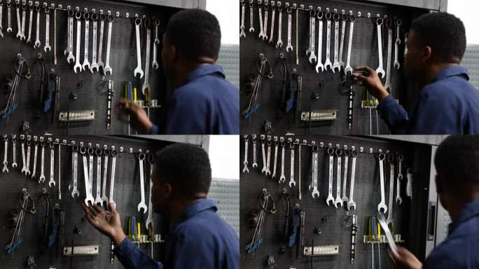汽车修理店的黑人机械师从工具箱里拿扳手的后景