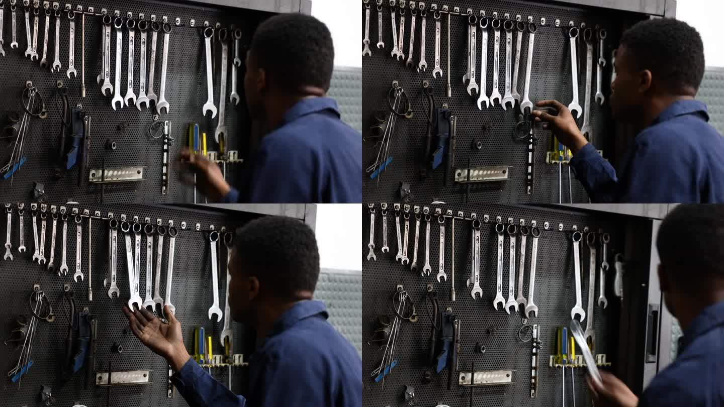 汽车修理店的黑人机械师从工具箱里拿扳手的后景