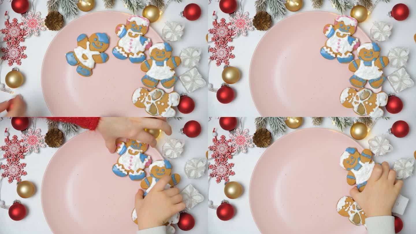 一家人从盘子里拿起男人形状的姜饼圣诞饼干。双手俯视图。