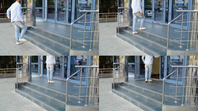 一个拄着拐杖的盲人走进大楼的台阶