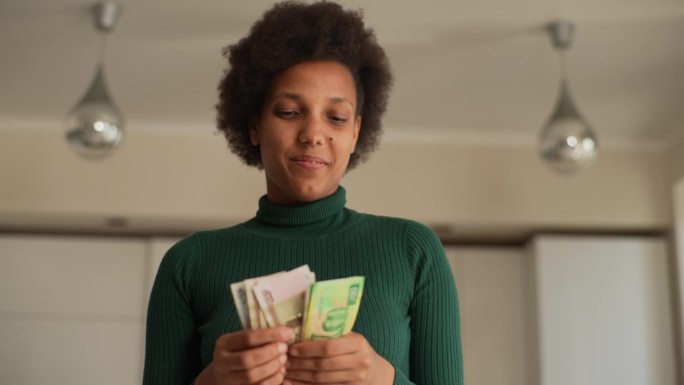从低角度看快乐的非洲年轻女子数着俄罗斯卢布钞票，拿着银行贷款的工资信贷，在家数现金金融。
