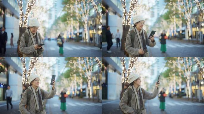 快乐的游客在圣诞节期间用智能手机在美丽的街道上拍照。