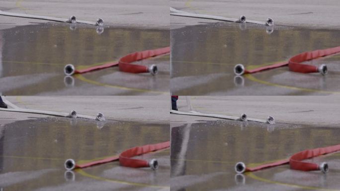一个特写镜头捕捉到一根带有强大水流的消防水管，突出了这种消防工具在行动中的准确性和力量