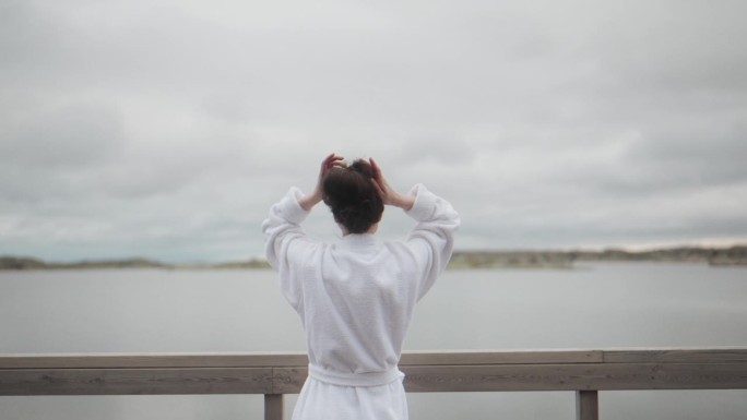 快乐的女人穿着浴袍，享受着他的自由