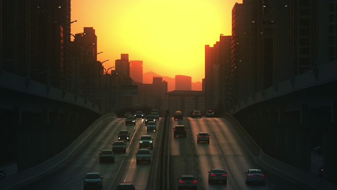 日落夕阳下城市道路行驶的汽车