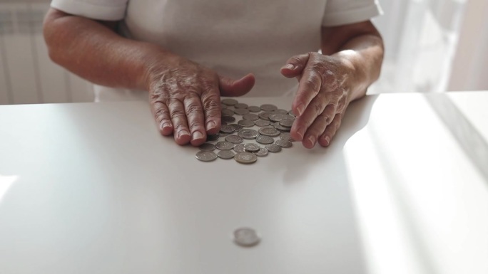 女性的手在数桌上散落的硬币的特写。金融危机，预算，储蓄，金钱积累。现金。贫困。