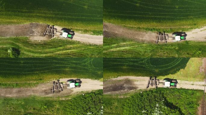 农用拖拉机带着耕作设备沿着乡间土路驶向田地，无人机拍摄
