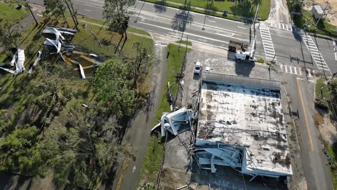 摇摇欲坠的商店屋顶:飓风过后的小镇。北佛罗里达州佩里市，扭曲的屋顶和遍布街头的废墟。航拍镜头与轨道摄