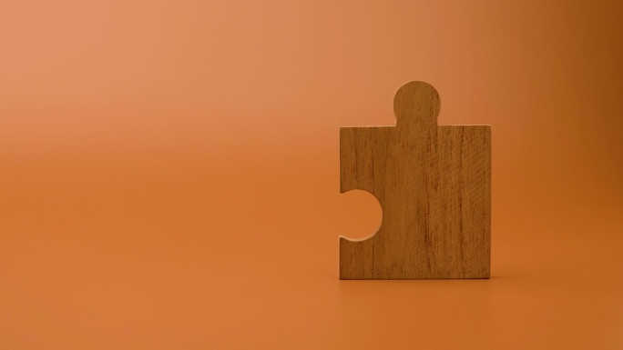 橙色背景上的拼图块，把拼图块放好，团结，团队，正能量。