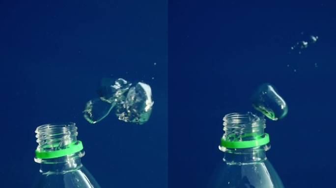 气泡从塑料瓶中冒出来的特写，塑料瓶沉入蓝色深处