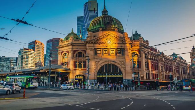 澳大利亚维多利亚州墨尔本市弗林德斯街火车站拥挤的通勤者和游客步行和穿越有轨电车的时间流逝