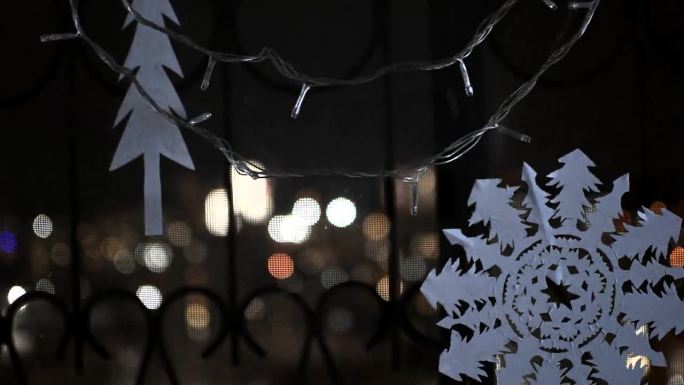 雪花和圣诞树剪纸，在窗户上挂着闪闪发光的花环