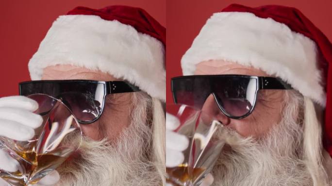 调皮的圣诞老人戴着墨镜喝着威士忌和眨眼