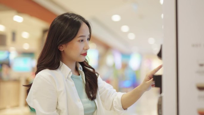 亚洲女性用智能手表扫描付款。