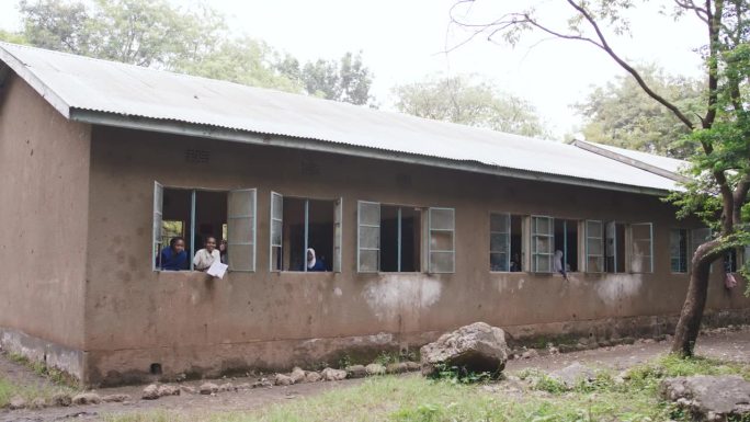 学生站在窗前的慢镜头。乡村小学校的外观。农村教育建设。