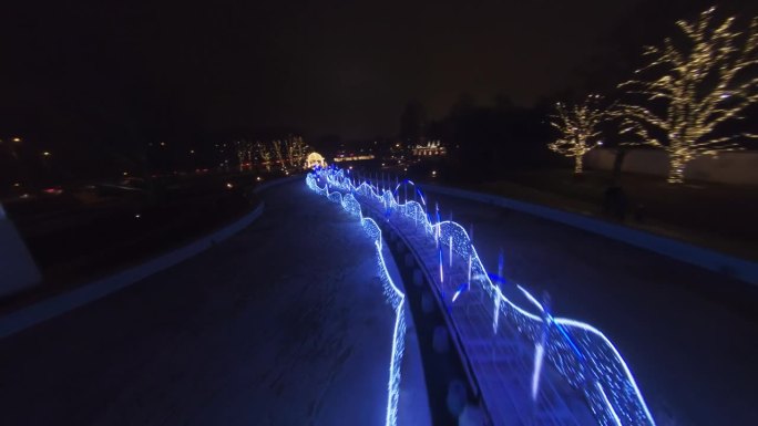 夜晚，FPV无人机在充满圣诞装饰的城市上空飞行