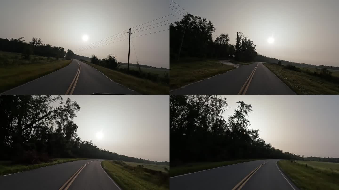 黎明时分，在森林覆盖的农业区，司机沿着弯曲空旷的乡村公路行驶