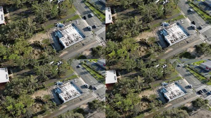 北佛罗里达的商店建筑变成了废墟:飓风肆虐后，屋顶被撕裂，碎片散落在佛罗里达州佩里。航拍镜头，镜头向后