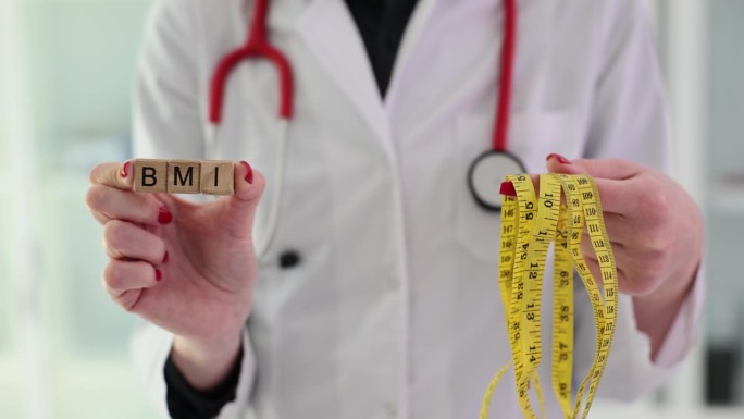 医生在诊所里拿着词BMI和仪表测量