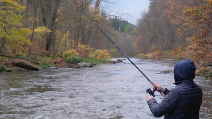 一个人在美国的一条山河中钓鱼。钓鱼是一种爱好